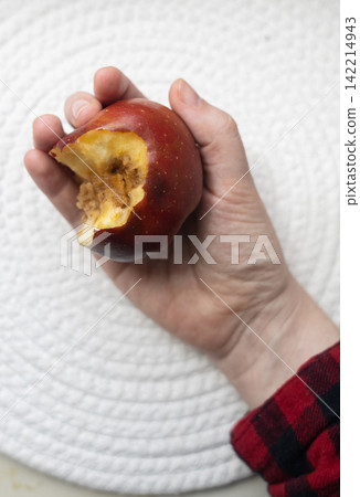 A hand holding a bitten rotten red apple showing internal browning, monilinia fungal rot, and core disease. Concept of fruit pathology and spoiled food. A hand holding a bitten rotten red apple showing internal browning, monilinia fungal rot, and core disease. Concept of fruit pathology and spoiled food. 142214943