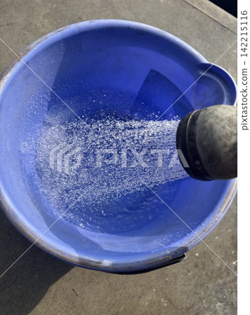 用淋浴噴頭往桶子裡裝滿水。 用淋浴噴頭往桶子裡裝滿水。 142215116