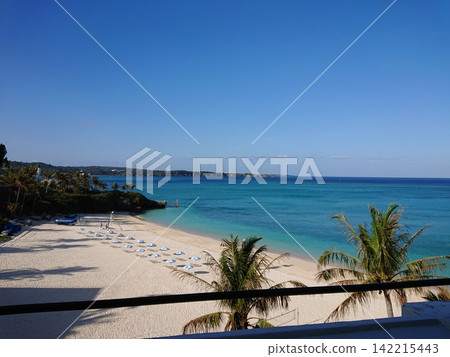 A sandy beach in a tropical resort with a clear blue sky and blue sea. A sandy beach in a tropical resort with a clear blue sky and blue sea. 142215443
