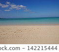 A white sandy beach stretches out before you, under a clear blue sky and a crystal-clear sea. 142215444