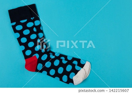 Pair of blue polka dot socks on bright blue background with copy space. Funny colorful casual hosiery top view Pair of blue polka dot socks on bright blue background with copy space. Funny colorful casual hosiery top view 142215607