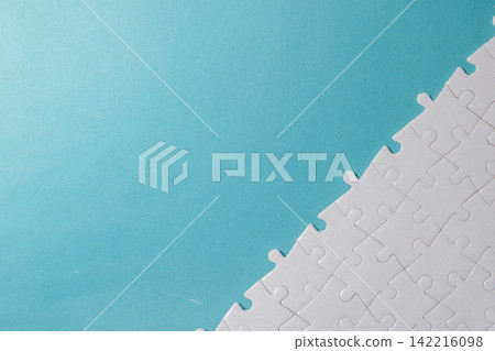Diagonal composition of white jigsaw puzzle pieces in bottom right with blue empty copy space. High Quality Photo Diagonal composition of white jigsaw puzzle pieces in bottom right with blue empty copy space. High Quality Photo 142216098