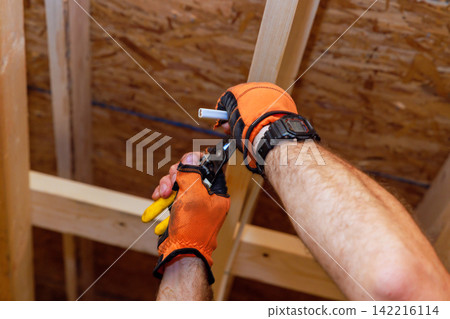 Electrical works on installing electrical wiring in wooden ceiling structure. Electrical works on installing electrical wiring in wooden ceiling structure. 142216114