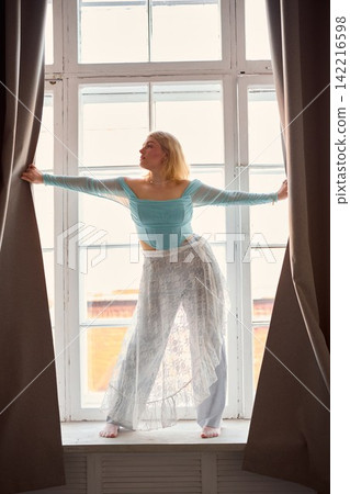 Peaceful woman delights in morning calmness within elegant hotel Peaceful woman delights in morning calmness within elegant hotel 142216598
