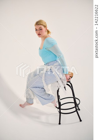 Caucasian woman in contemplative pose on stool performer rehearsal 142216622