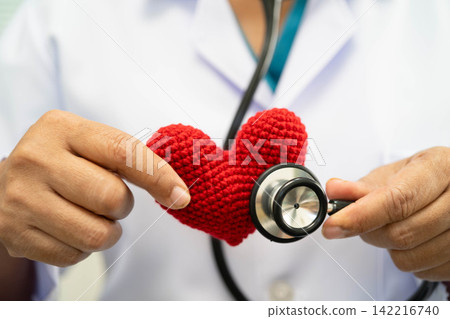 Asian woman doctor holding red heart for health in hospital. Asian woman doctor holding red heart for health in hospital. 142216740