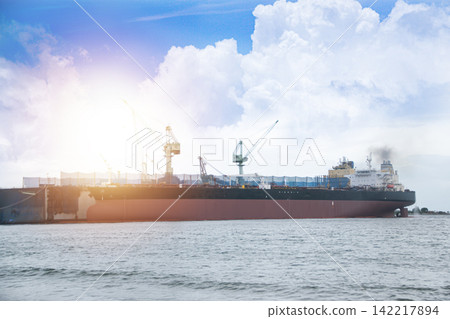 A large ocean-going vessel is docked for maintenance. A large ocean-going vessel is docked for maintenance. 142217894
