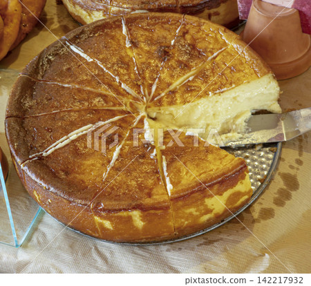 Freshly baked Basque cheesecake sliced on a tray with a spatula ready for serving Freshly baked Basque cheesecake sliced on a tray with a spatula ready for serving 142217932