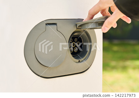 An electric vehicle's charging port with the connector cover open. An electric vehicle's charging port with the connector cover open. 142217973