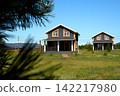 Modern vacation cottages with solar panels in a green rural landscape. 142217980