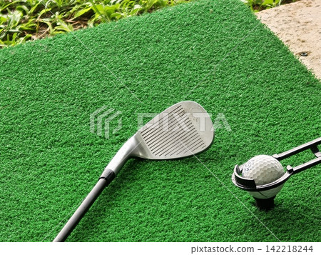 Golf Wedge Club and Teed Ball on Green Driving Range Mat Golf Wedge Club and Teed Ball on Green Driving Range Mat 142218244