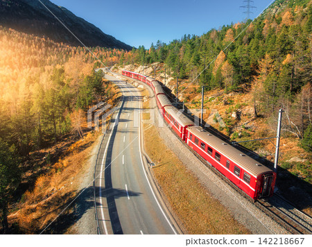 Aerial view of red train, river in mountains, road, orange forest 142218667