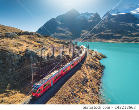Aerial view of red Bernina Express train near turquoise lake Aerial view of red Bernina Express train near turquoise lake 142218668