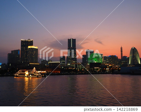 The Ferris wheel lit up in green and the evening view of Minato Mirai. The Ferris wheel lit up in green and the evening view of Minato Mirai. 142218869