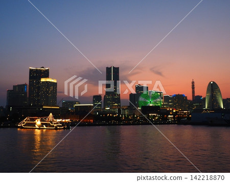 The Ferris wheel, shining in green and white, stands out beautifully in the twilight of Minato Mirai. The Ferris wheel, shining in green and white, stands out beautifully in the twilight of Minato Mirai. 142218870