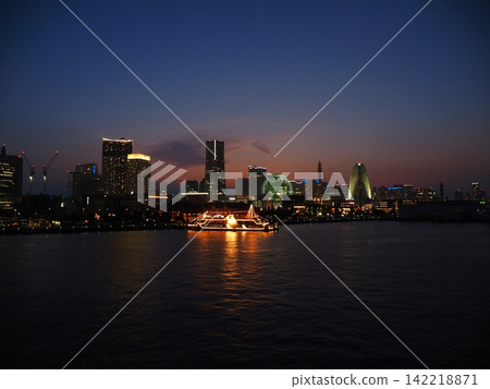 The lights of sightseeing boats reflected on the water in the nighttime Minato Mirai area. The lights of sightseeing boats reflected on the water in the nighttime Minato Mirai area. 142218871