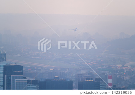 Airplane flying over Taipei city in misty morning Airplane flying over Taipei city in misty morning 142219036