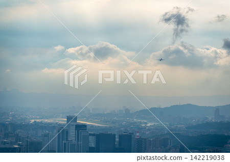 Airplane flying over Taipei cityscape in Taiwan with dramatic clouds Airplane flying over Taipei cityscape in Taiwan with dramatic clouds 142219038