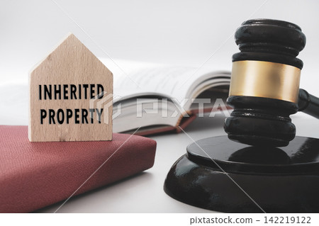Judge gavel with Inherited property text on wooden house on white background. Inheritance Law Concept. Judge gavel with Inherited property text on wooden house on white background. Inheritance Law Concept. 142219122