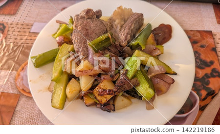 Grilled beef steak with zucchini potatoes and purple onion on a plate Grilled beef steak with zucchini potatoes and purple onion on a plate 142219186