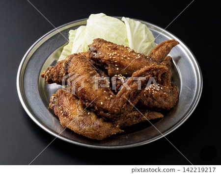 Chicken wings photographed against a black background 142219217
