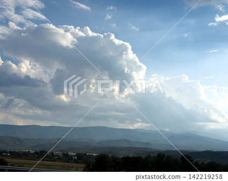 Towering White Clouds Above Distant Blue Mountain Landscape 142219258