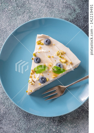 Creamy Mascarpone Cheesecake Slice Served With Blueberries Pistachios Maple Syrup And Mint Leaves 142219491