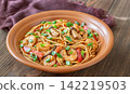 Asian stir fry udon noodles with prawns mushrooms vegetables in rustic ceramic bowl 142219503