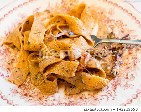 eating pappardelle pasta with pulled beef eating pappardelle pasta with pulled beef 142219558