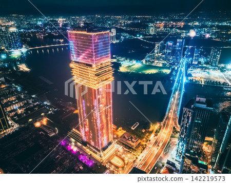 Aerial night view of Ho Chi Minh City skyline with glowing skyscrapers and neon lights, Drone panorama of Saigon downtown, illuminated towers and busy streets of vibrant city Aerial night view of Ho Chi Minh City skyline with glowing skyscrapers and neon lights, Drone panorama of Saigon downtown, illuminated towers and busy streets of vibrant city 142219573
