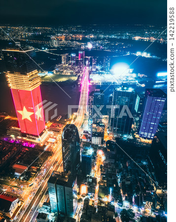 Aerial night view of Ho Chi Minh City skyline with glowing skyscrapers and neon lights, Drone panorama of Saigon downtown, illuminated towers and busy streets of vibrant city Aerial night view of Ho Chi Minh City skyline with glowing skyscrapers and neon lights, Drone panorama of Saigon downtown, illuminated towers and busy streets of vibrant city 142219588