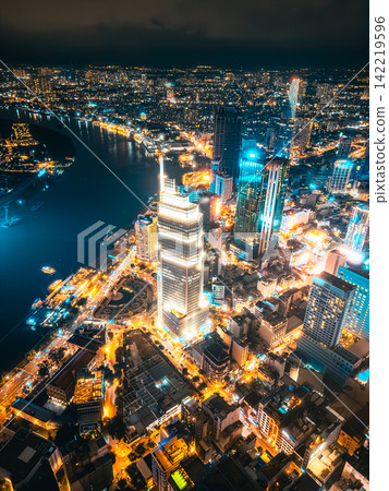 Aerial night view of Ho Chi Minh City skyline with glowing skyscrapers and neon lights, Drone panorama of Saigon downtown, illuminated towers and busy streets of vibrant city Aerial night view of Ho Chi Minh City skyline with glowing skyscrapers and neon lights, Drone panorama of Saigon downtown, illuminated towers and busy streets of vibrant city 142219596