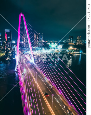 modern cable-stayed Thu Thiem suspension bridge over Saigon river with colourful illumination neon led lights, Ho Chi Minh city, Vietnam aerial drone view modern cable-stayed Thu Thiem suspension bridge over Saigon river with colourful illumination neon led lights, Ho Chi Minh city, Vietnam aerial drone view 142219604