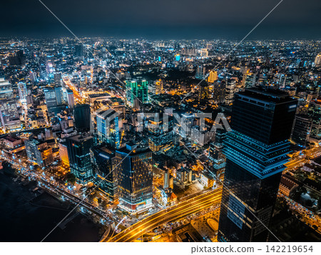 night view of illuminated Ho Chi Minh city skyline and Saigon river, neon street lights of financial downtown district with tall skyscraper towers, Vietnam aerial drone view night view of illuminated Ho Chi Minh city skyline and Saigon river, neon street lights of financial downtown district with tall skyscraper towers, Vietnam aerial drone view 142219654