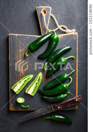Black jalapeno with knife on rustic wooden cutting board Black jalapeno with knife on rustic wooden cutting board 142219690