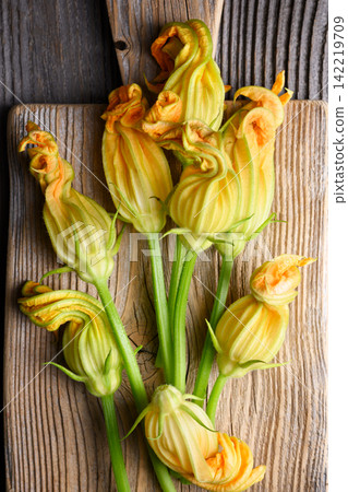 Top view zucchini blossoms on wooden board Top view zucchini blossoms on wooden board 142219709