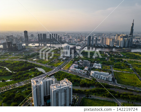 beautiful sunset over Ho Chi Minh city skyline and Saigon river, green tropical park and financial downtown district with tall skyscraper towers, Vietnam aerial drone view beautiful sunset over Ho Chi Minh city skyline and Saigon river, green tropical park and financial downtown district with tall skyscraper towers, Vietnam aerial drone view 142219724