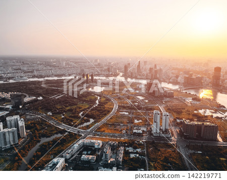beautiful sunset over Ho Chi Minh city skyline and Saigon river, green tropical park and financial downtown district with tall skyscraper towers, Vietnam aerial drone view beautiful sunset over Ho Chi Minh city skyline and Saigon river, green tropical park and financial downtown district with tall skyscraper towers, Vietnam aerial drone view 142219771