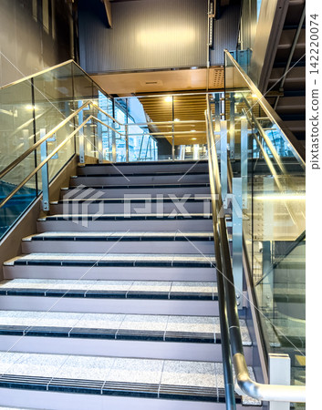 A stylish indoor staircase with beautiful metal and glass textures. A stylish indoor staircase with beautiful metal and glass textures. 142220074
