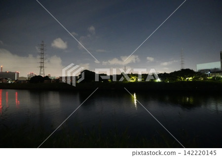夜幕下的河流,對岸的城市景觀,以及輸電塔。 夜幕下的河流,對岸的城市景觀,以及輸電塔。 142220145