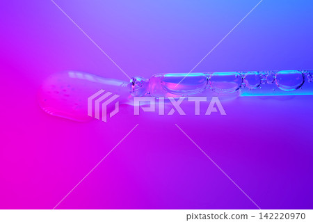 Clear serum dripping from pipette on neon background Clear serum dripping from pipette on neon background 142220970