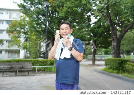 A man cooling himself with a hand fan. A man cooling himself with a hand fan. 142221117