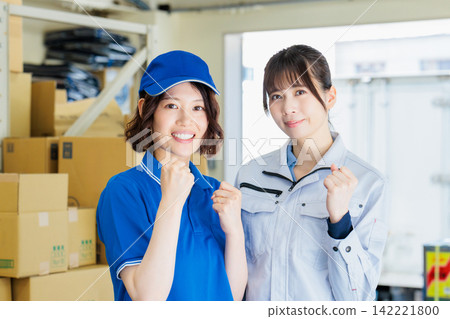 Women working in work clothes in a warehouse Women working in work clothes in a warehouse 142221800