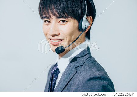 A man in a suit wearing a headset. A man in a suit wearing a headset. 142222597