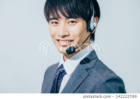 一名身穿西裝、戴著耳機的男子。 142222599