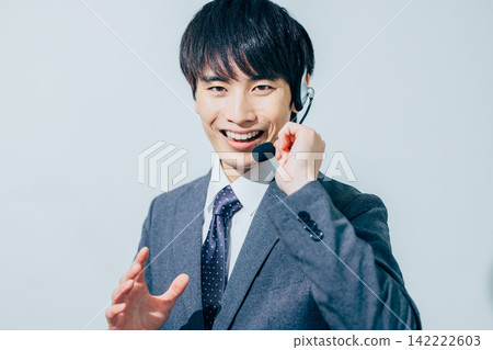 一名身穿西裝、戴著耳機的男子。 142222603