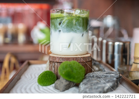 An Iced Matcha latte drink ready for drink. A creamy drink made by mixing finely ground green tea powder with hot water, then adding hot or cold milk. An Iced Matcha latte drink ready for drink. A creamy drink made by mixing finely ground green tea powder with hot water, then adding hot or cold milk. 142222721