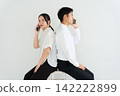 一男一女背對背操作智慧型手機。 142222899
