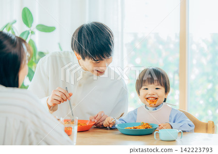 A family of three enjoys a pasta lunch. A family of three enjoys a pasta lunch. 142223793