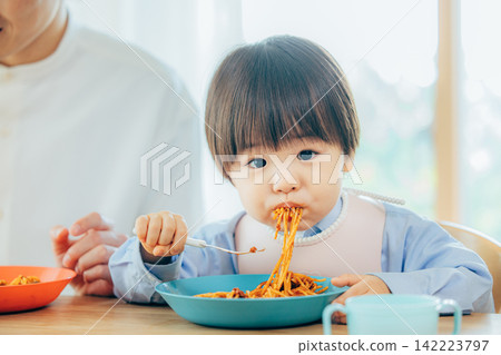 A family of three enjoys a pasta lunch. A family of three enjoys a pasta lunch. 142223797